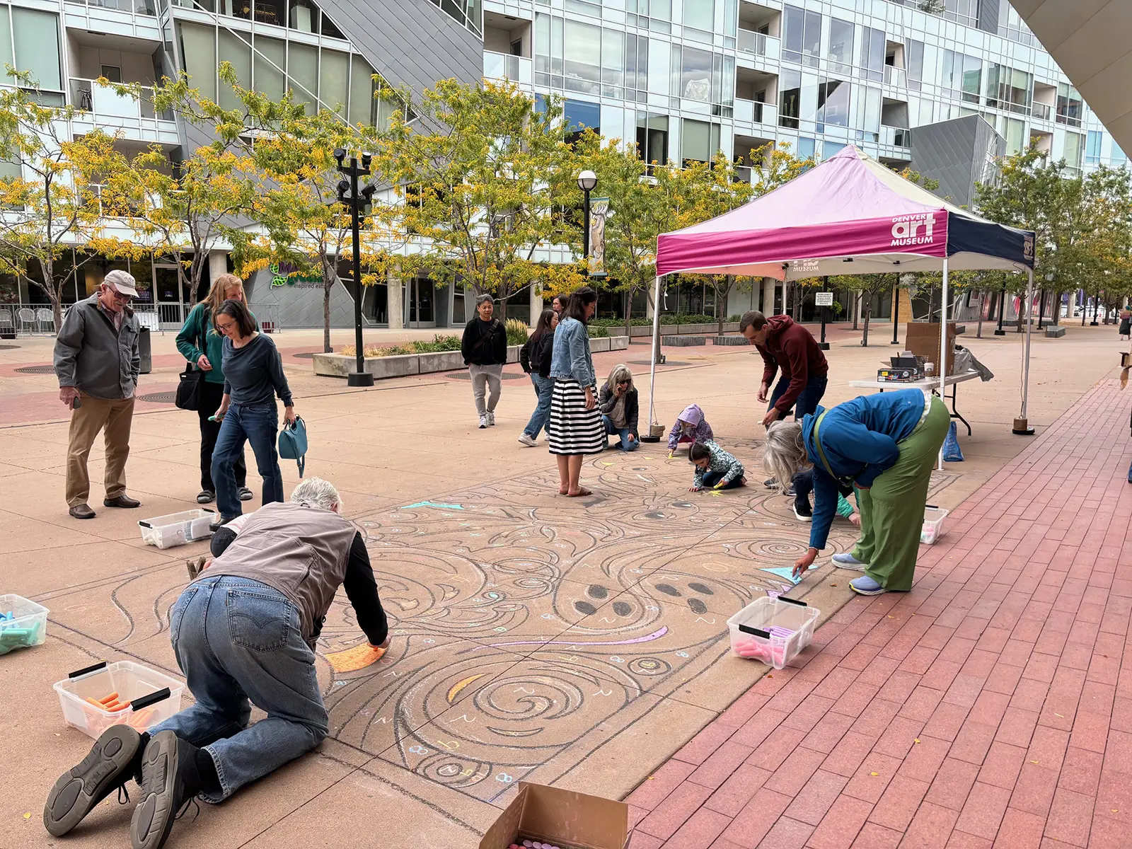 People coloring with chalk in front of the Denver Art Museum during the Millionth Kid celebration sponsored by Bellco