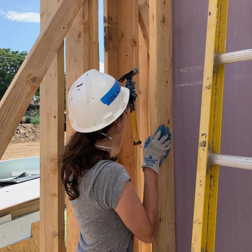 A GFM|CenterTable team member hammers a nail while volunteering with Habitat for Humanity